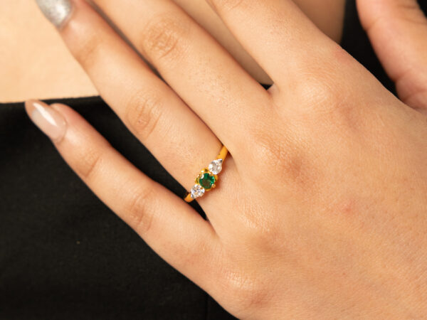 Elegant emerald ring in 18k gold, featuring a vibrant green emerald at the center, surrounded by a delicate halo of sparkling diamonds. Perfect for adding timeless sophistication to any look.